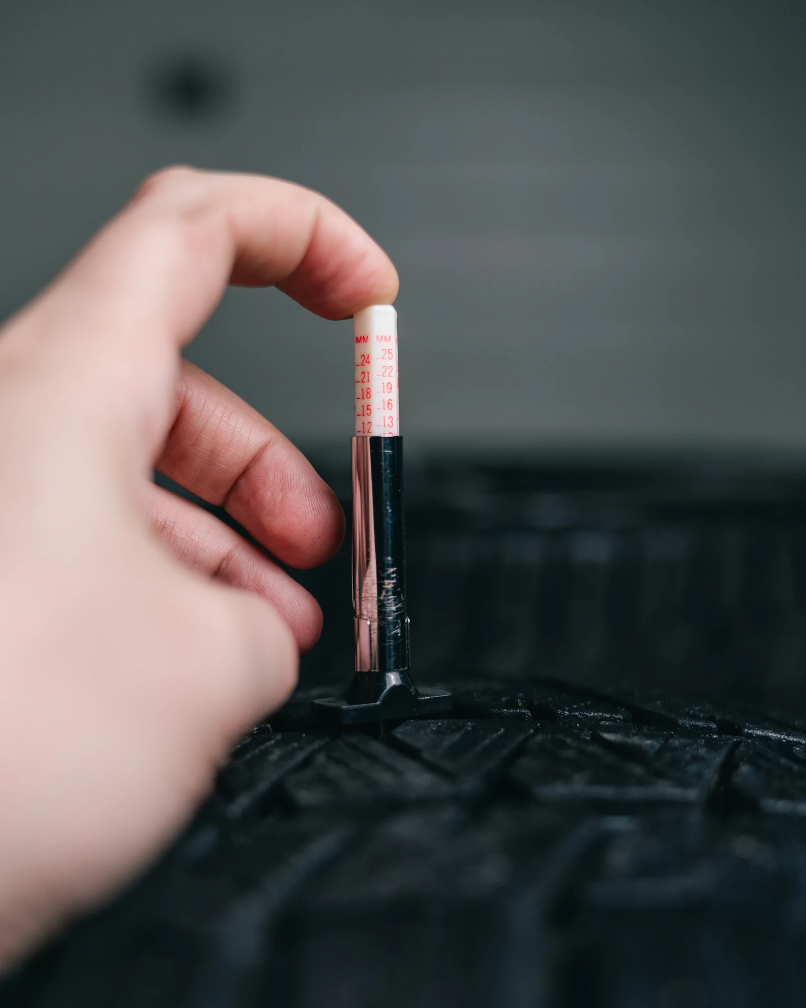 Tread depth gauge pressed into a groove of a tire